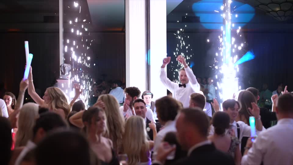 Guests dancing as cold spark fountains go off behind the dance floor